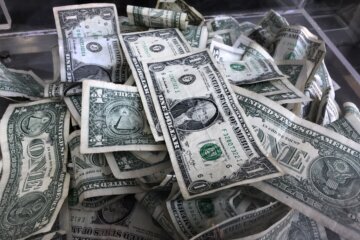 FILE - In this April 3, 2019, photo a tip box is filled with U.S. currency in New York. During inflation, consumers can adjust their spending and saving strategies to help lessen the impact that inflation has on the value of their money. It’s important to have liquid cash set aside for emergencies, but beyond an emergency fund, there are other ways to save money and help retain its value. (AP Photo/Mark Lennihan, File)