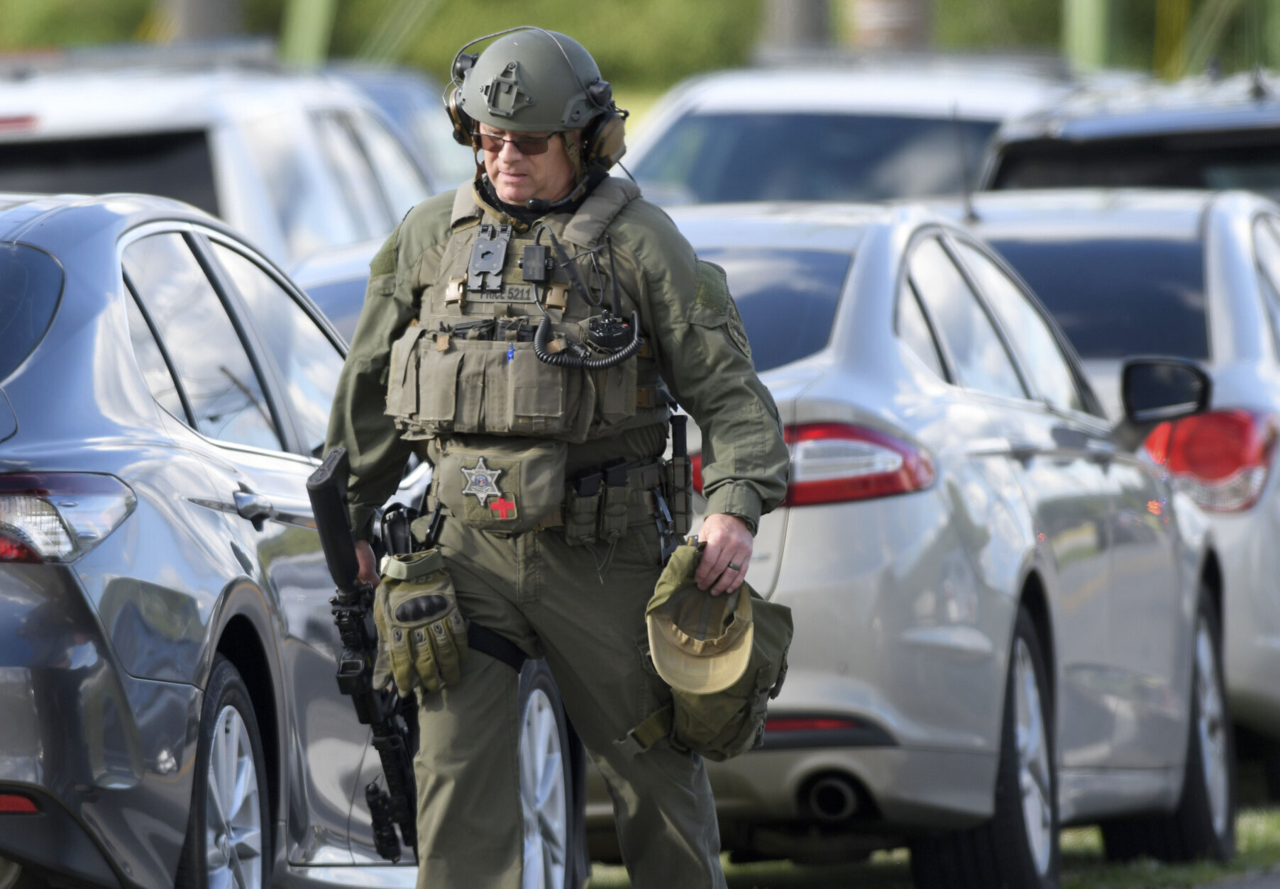 A tactical police officer walks near where a man opened fire at a business, killing three people before the suspect and a state trooper were wounded in a shootout, according to authorities, in Smithsburg, Md., Thursday, June 9, 2022. The Washington County (Md.) Sheriff's Office said in a news release that three victims were found dead at Columbia Machine Inc. and a fourth victim was critically injured.  (AP Photo/Steve Ruark)