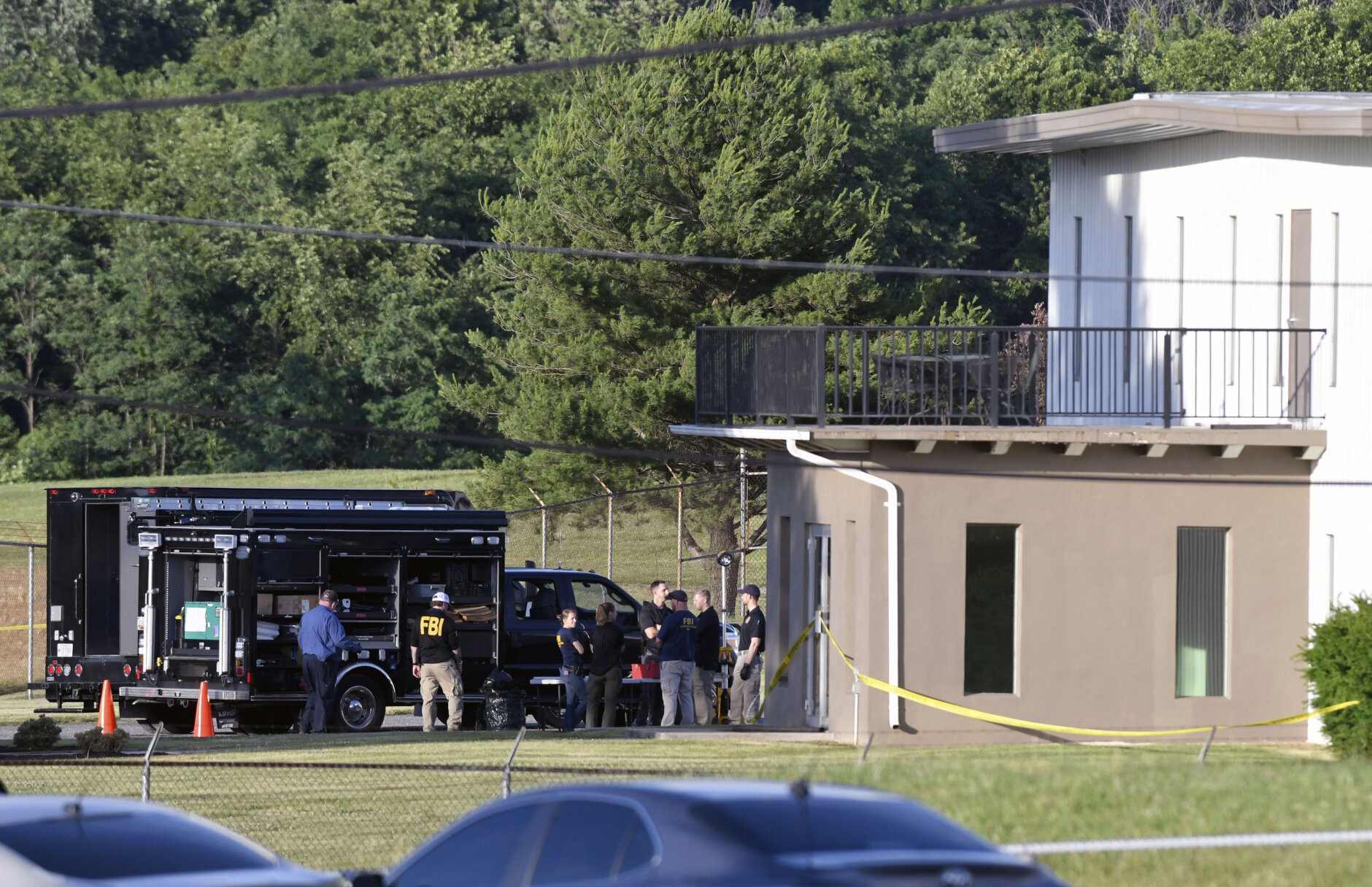 Law enforcement works near where a man opened fire at a business, killing three people before the suspect and a state trooper were wounded in a shootout, according to authorities, in Smithsburg, Md., Thursday, June 9, 2022. The Washington County ( Md.) Sheriff's Office said in a news release that three victims were found dead at Columbia Machine Inc. and a fourth victim was critically injured.  (AP Photo/Steve Ruark)