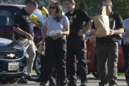 Law enforcement officials remove evidence from one of two cars that were involved in a shooting involving a Maryland State Police officer on Thursday, June 9, 2022 near Smithsburg, Md. An employee opened fire at a manufacturing business in rural western Maryland on Thursday, killing three coworkers before the suspect and a state trooper were wounded in a shootout, authorities said. (AP Photo/Timothy Jacobsen)