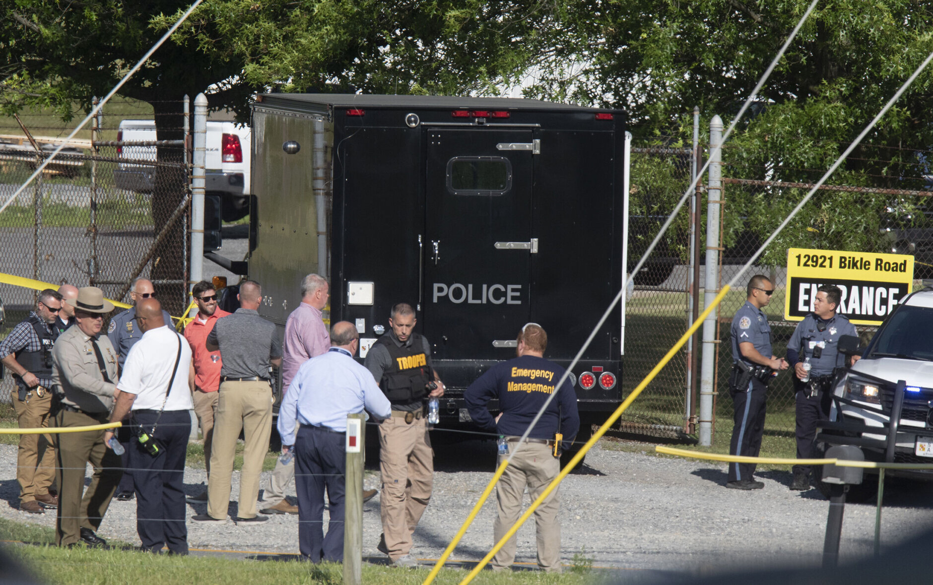 Law enforcement officials gather outside the entrance to Columbia Machine Inc on Thursday, June 9, 2022 near Smithsburg, Md. An employee opened fire at a manufacturing business in rural western Maryland on Thursday, killing three coworkers before the suspect and a state trooper were wounded in a shootout, authorities said.  (AP Photo/Timothy Jacobsen)