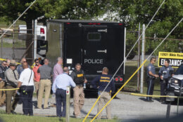 Law enforcement officials gather outside the entrance to Columbia Machine Inc on Thursday, June 9, 2022 near Smithsburg, Md. An employee opened fire at a manufacturing business in rural western Maryland on Thursday, killing three coworkers before the suspect and a state trooper were wounded in a shootout, authorities said. (AP Photo/Timothy Jacobsen)