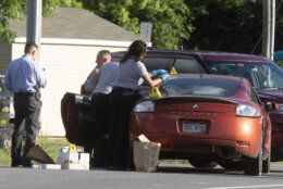 Law enforcement officials process evidence from one of two cars that were involved in a shooting involving a Maryland State Police officer on Thursday, June 9, 2022 along Mt. Aetna Road near Smithsburg, Md. An employee opened fire at a manufacturing business in rural western Maryland on Thursday, killing three coworkers before the suspect and a state trooper were wounded in a shootout, authorities said. (AP Photo/Timothy Jacobsen)