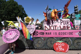 Demonstrators decorate a mock tank during the Poor People's Campaign, "Moral March" on Pennsylvania Avenue in Washington, Saturday, June 18, 2022. (AP Photo/Jose Luis Magana)