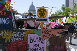 With the U.S. Capitol in the background, demonstrators decorate a mock tank during the Poor People's Campaign, "Moral March" on Pennsylvania Avenue in Washington, Saturday, June 18, 2022. (AP Photo/Jose Luis Magana)