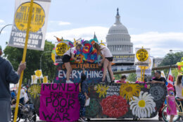 With the U.S. Capitol in the background, demonstrators decorate a mock tank during the Poor People's Campaign, "Moral March" on Pennsylvania Avenue in Washington, Saturday, June 18, 2022. (AP Photo/Jose Luis Magana)