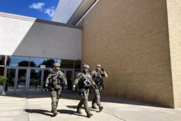 Law enforcement personnel walk outside Tysons Corner Center mall in Tysons Corner, Va., Saturday, June 18, 2022. Authorities said a person fired a gun during a fight inside the mall. (Salwan Georges/The Washington Post via AP)