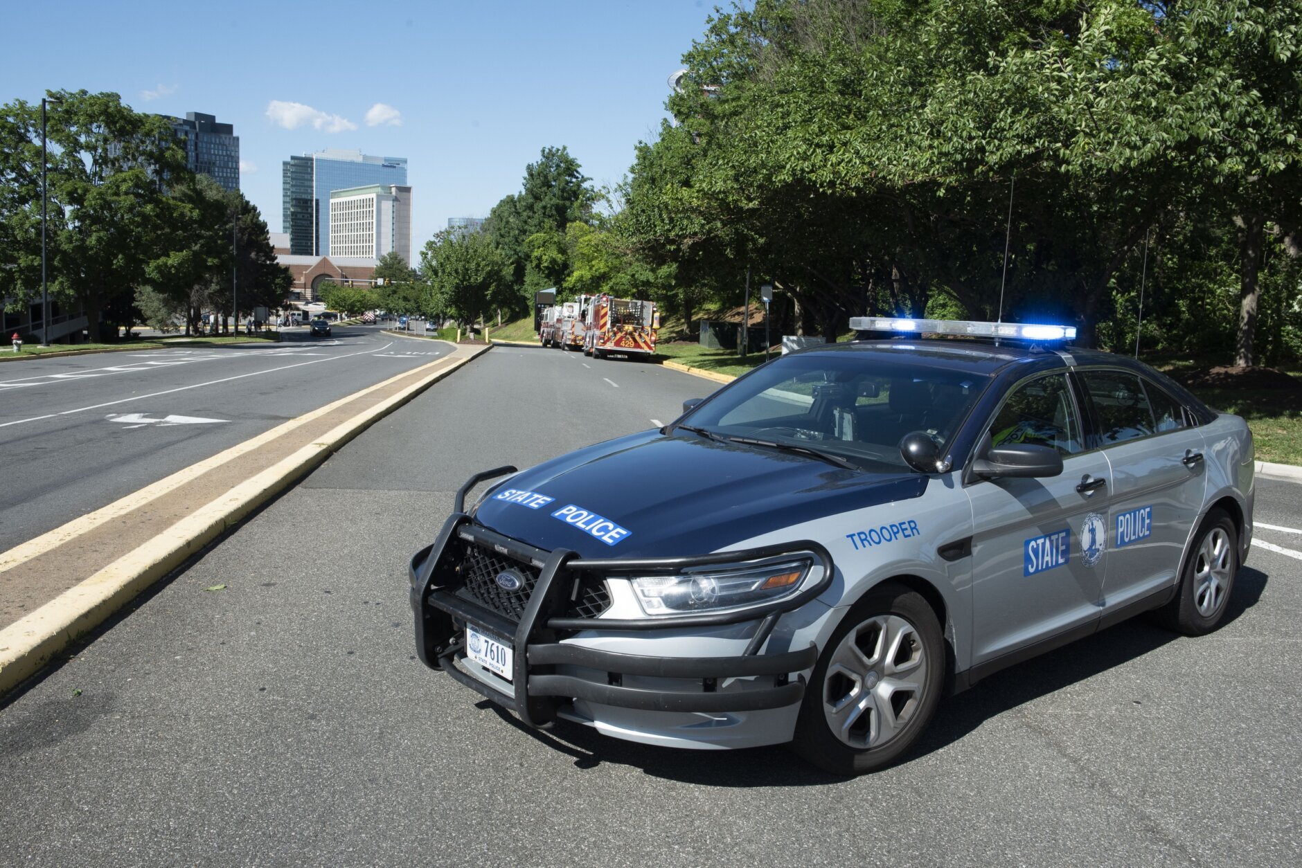 A Virginia State Police officer blocks the entrance to the Tysons Corner Center mall following a shooting inside the shopping center, in Tysons Corner, Va., Saturday, June 18, 2022. (AP Photo/Cliff Owen)