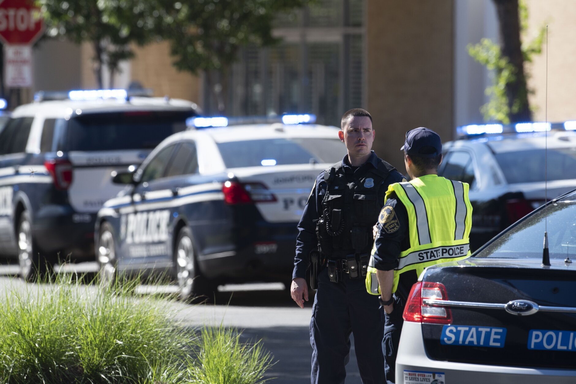 Virginia State Police stand watch outside the Bloomingdale's store, following a shooting inside the Tysons Corner Center mall, in Tysons Corner, Va., Saturday, June 18, 2022. (AP Photo/Cliff Owen)