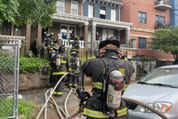 DC Firefighters rushing into vacant house in Northeast DC. The simulation is part of a National training video they were selected to teach other firefighters about the dangers of fighting rowhouse blazes.