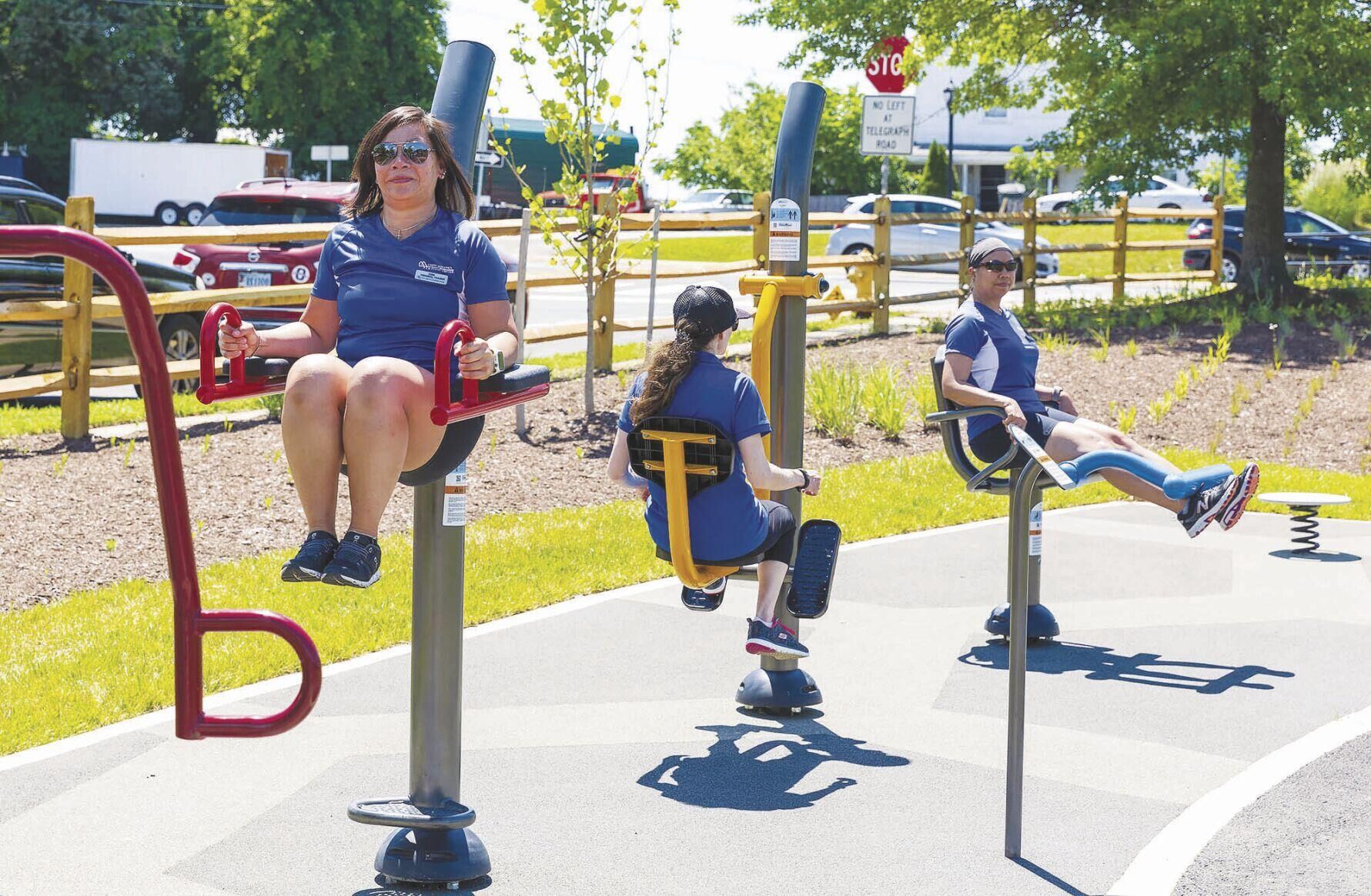 Members of Prince William County's fitness team try out some of the workout stations at the new park. (Paul Lara/Inside NOVA)