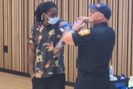 DC EMS Captain Charles Steptoe and an audience member demonstrate the proper use of a tourniquet to keep a shooting victim alive until first responders arrive. 