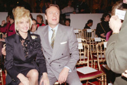 Ivana Trump, former wife of real estate magnate Donald Trump, smiles as she watches the 1992 Spring/Summer Haute Couture collection by Italian fashion designer Mila Schon, in Paris, Jan. 26, 1992. Her escort is Riccardo Mazzucchelli  of Italy. (AP Photo/Jacques Brinon)