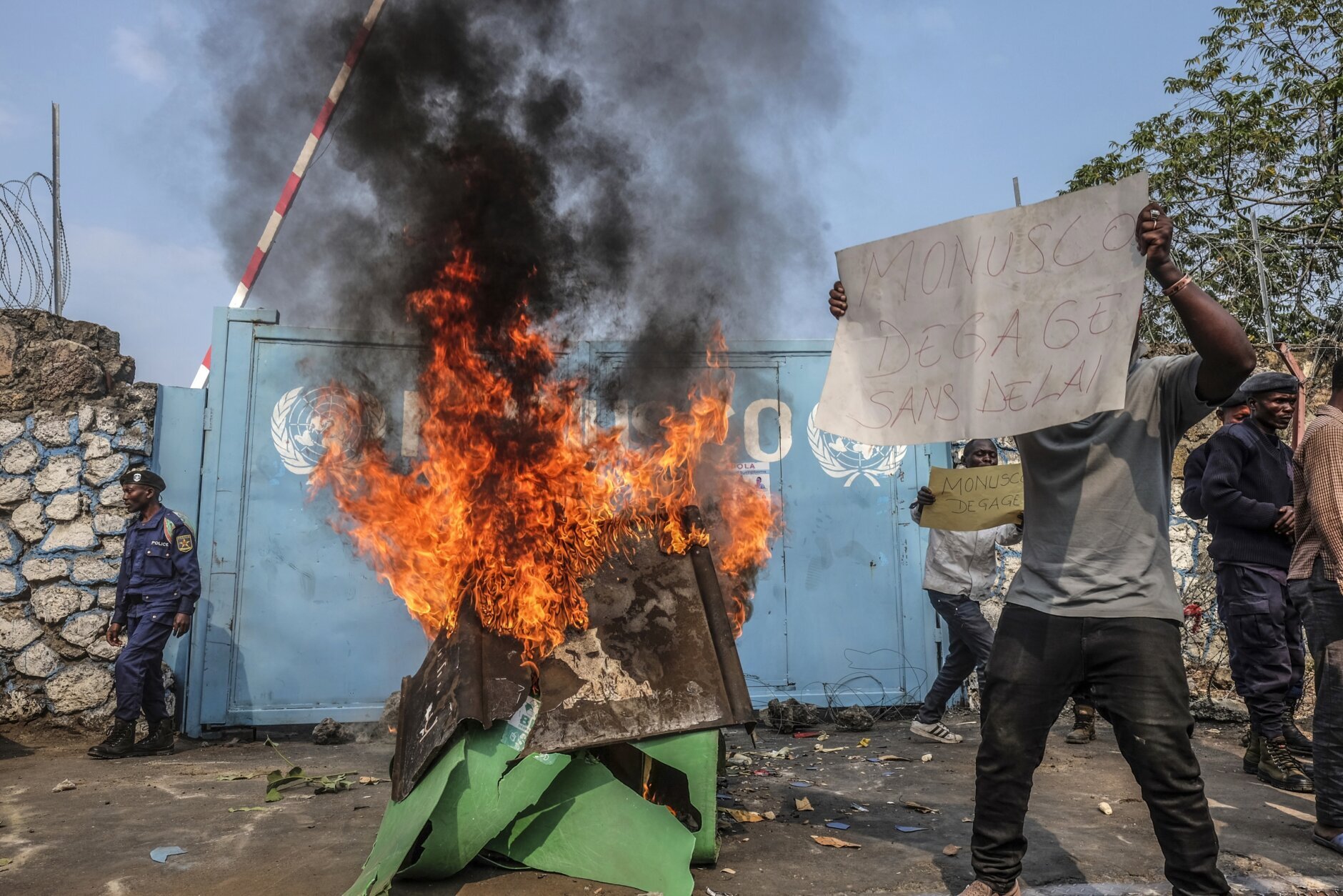 A resident holds a placard reading ''MONUSCO get out without delay'' as they protest against the United Nations peacekeeping force (MONUSCO) deployed in the Democratic Republic of the Congo, in Goma, Monday, July 25, 2022. Demonstrators said they were protesting against the rise of insecurity and inaction of the UN in the region. (AP Photo/Moses Sawasawa)