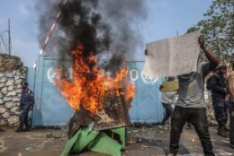 A resident holds a placard reading ''MONUSCO get out without delay'' as they protest against the United Nations peacekeeping force (MONUSCO) deployed in the Democratic Republic of the Congo, in Goma, Monday, July 25, 2022. Demonstrators said they were protesting against the rise of insecurity and inaction of the UN in the region. (AP Photo/Moses Sawasawa)