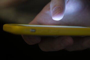 FILE - In this Sunday, Aug. 11, 2019, photo, a man uses a cell phone in New Orleans.  On Friday, July 22, 2022, The Associated Press reported on stories circulating online incorrectly claiming using the new 988 mental health hotline “will automatically route your geolocation information to local authorities.” (AP Photo/Jenny Kane, File)