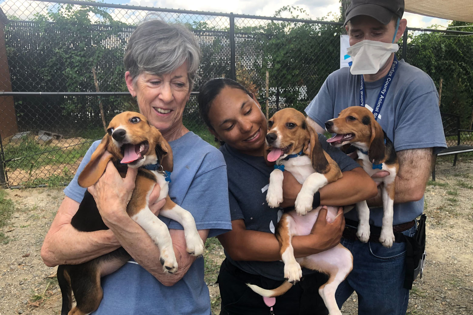 Volunteer Bernadette Carter; shelter caretaker Danielle McClammy; and volunteer Peter A. Fabry with the pups. (WTOP/Kristi King)