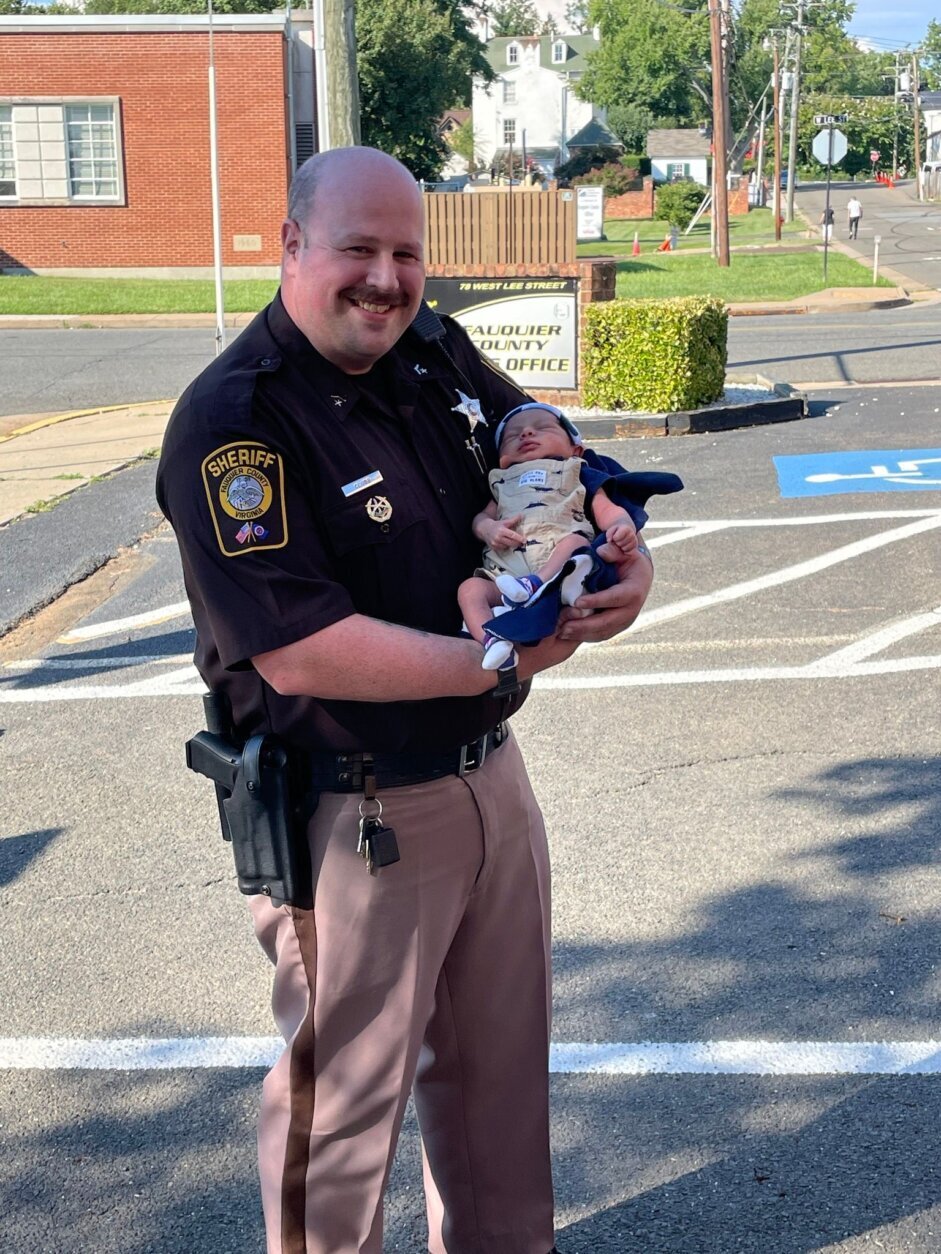 Baby and mother stopped by the Fauquier County Sheriff’s Office yesterday for an official introduction to Deputies Zachary Lawrence and John Clubb. (Courtesy Fauquier Co. Sheriff's Office via Facebook)