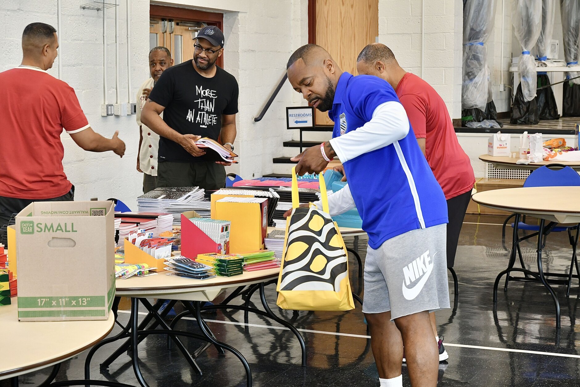 Volunteers help fill bags with school supplies at the "Stuff the Backpack Drive" on Saturday.