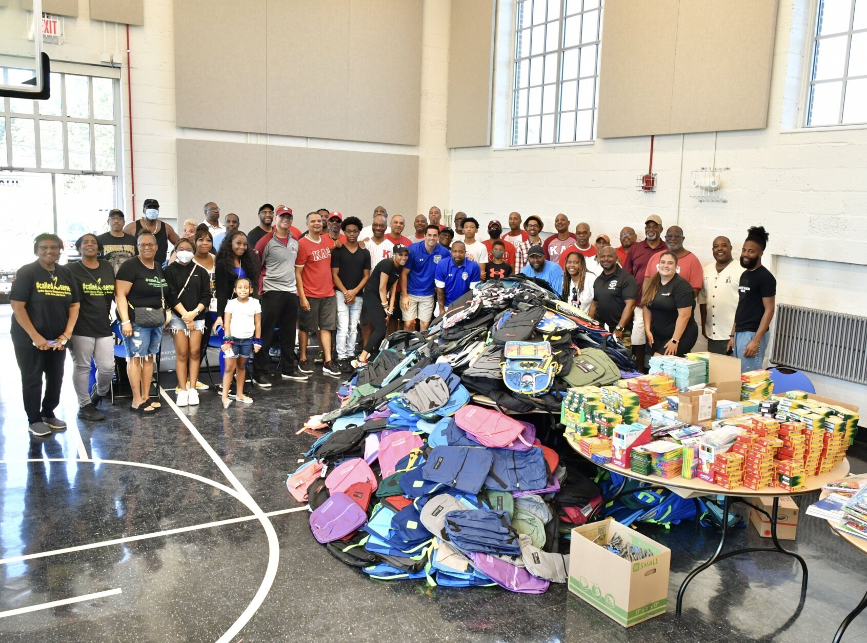 Volunteers help fill bags with school supplies at the "Stuff the Backpack" event on Saturday.