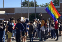 Students marching with rainbow flag