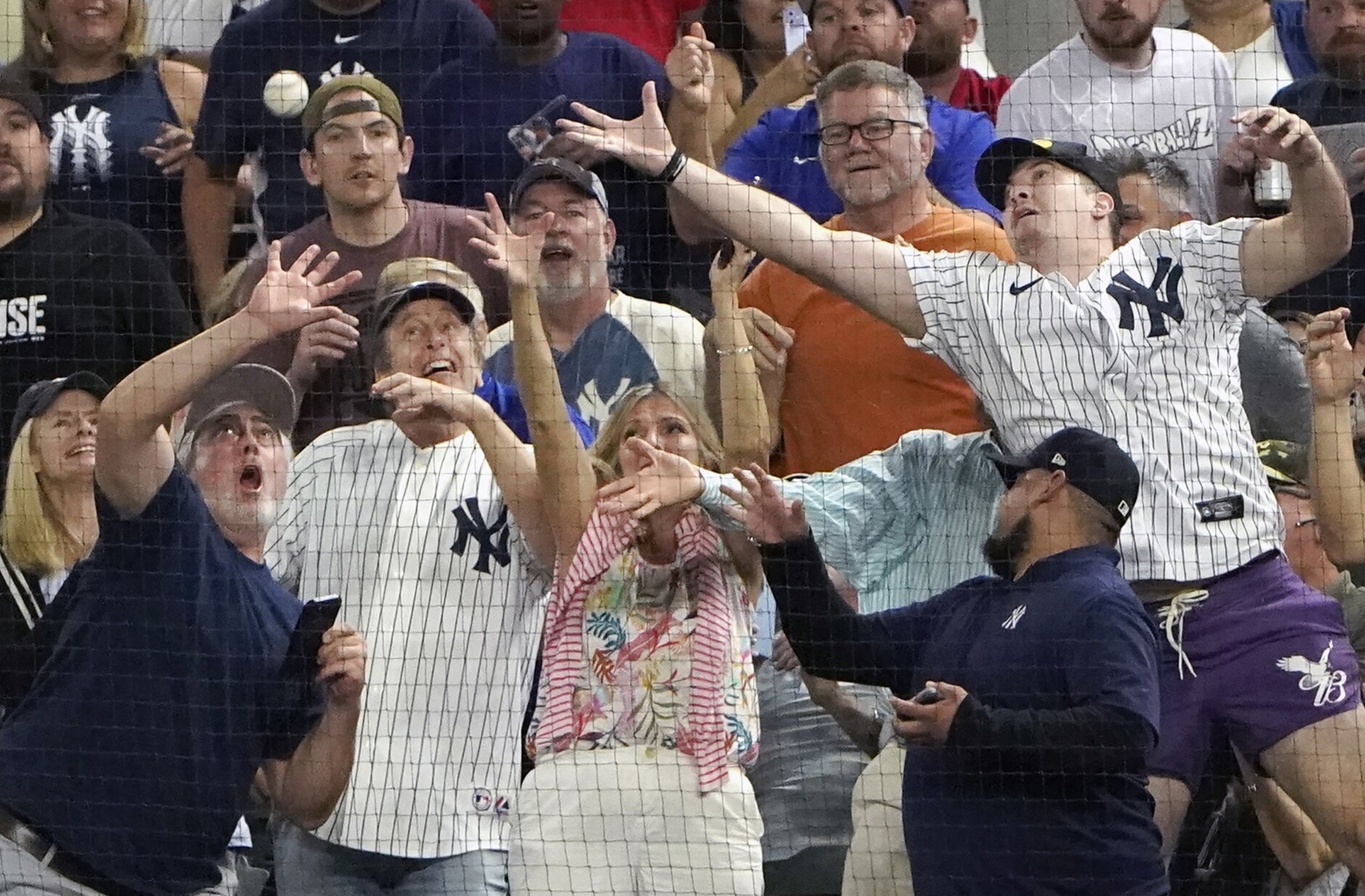 Fans reach for a foul ball by New York Yankees' Aaron Judge during the second inning in the second baseball game of a doubleheader against the Texas Rangers in Arlington, Texas, Tuesday, Oct. 4, 2022. (AP Photo/LM Otero)