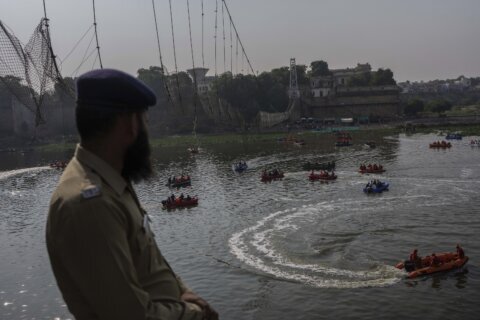 Officials probe India bridge collapse as divers comb river