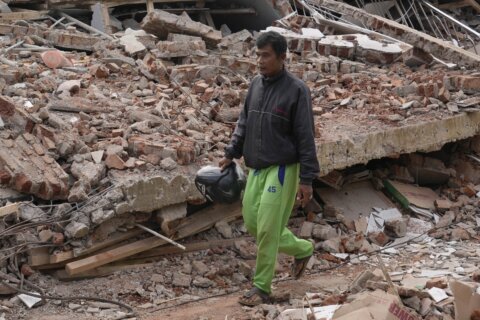 Indonesia quake survivor grieves 11 relatives as he rebuilds