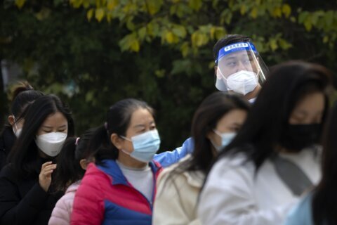 China eases some quarantine for travelers even as cases rise