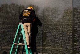 Volunteer on a ladder at the Vietnam Veterans Memorial..