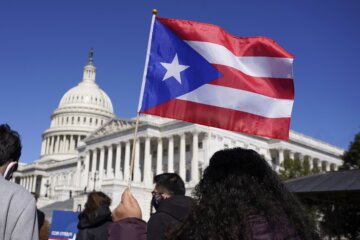 A woman waves the flag of Puerto Rico during a news conference on Puerto Rican statehood on Capitol Hill