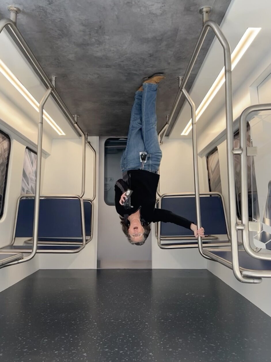 This trick is accomplished by having your picture taken inside a room built upside down. When you rotate the image it appears you are on the ceiling.