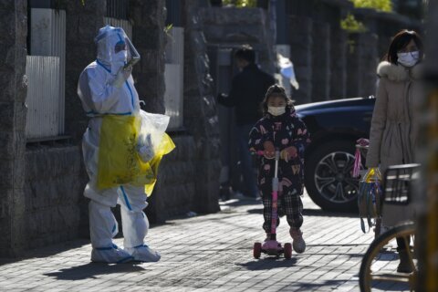 China eases some virus controls, searches pedestrians