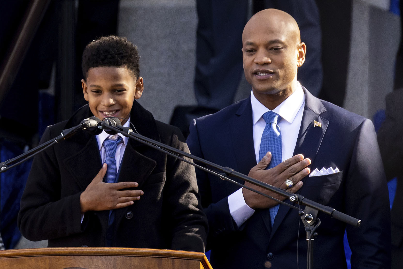 El gobernador de Maryland Wes Moore y su hijo James recitan el juramento de lealtad y servicio a la bandera de Estados Unidos durante la ceremonia de juramentación de Moore, el miércoles 18 de enero de 2023 en Annapolis, Maryland. (AP Foto/Julia Nikhinson)