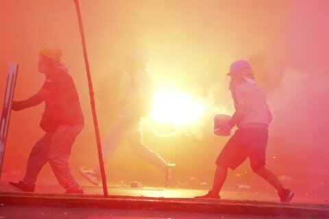 Peru’s protest ‘deactivators’ run toward tear gas to stop it