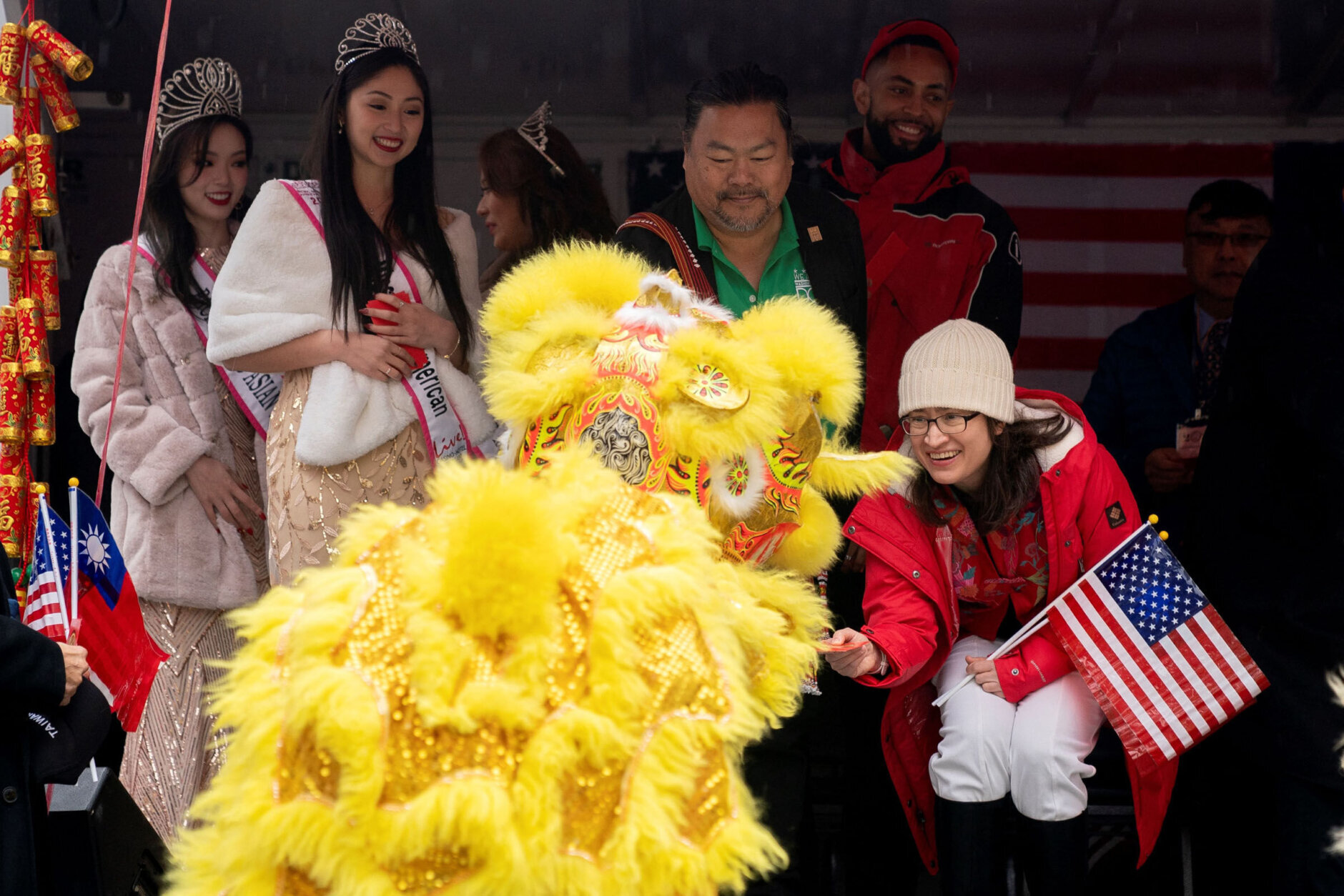 People give gifts to a performer following the Lunar New Year Parade in the Chinatown neighborhood of Washington, DC, on January 22, 2023. - 2023 is the year of the rabbit in the Chinese horoscope. (Photo by Stefani Reynolds / AFP) (Photo by STEFANI REYNOLDS/AFP via Getty Images)