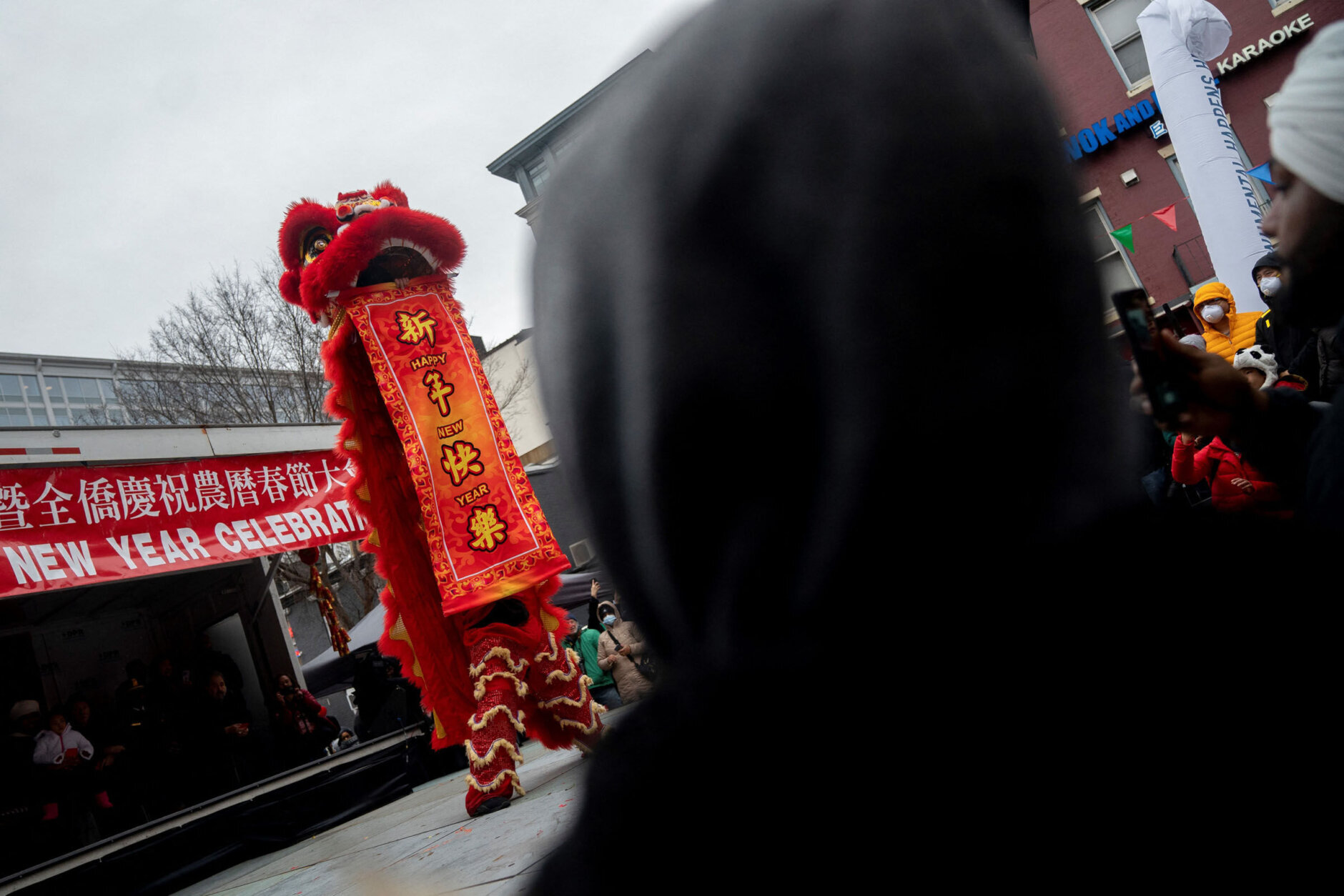 Onlookers watch performers on stage following the Lunar New Year Parade in the Chinatown neighborhood of Washington, DC, on January 22, 2023. - 2023 is the year of the rabbit in the Chinese horoscope. (Photo by Stefani Reynolds / AFP) (Photo by STEFANI REYNOLDS/AFP via Getty Images)