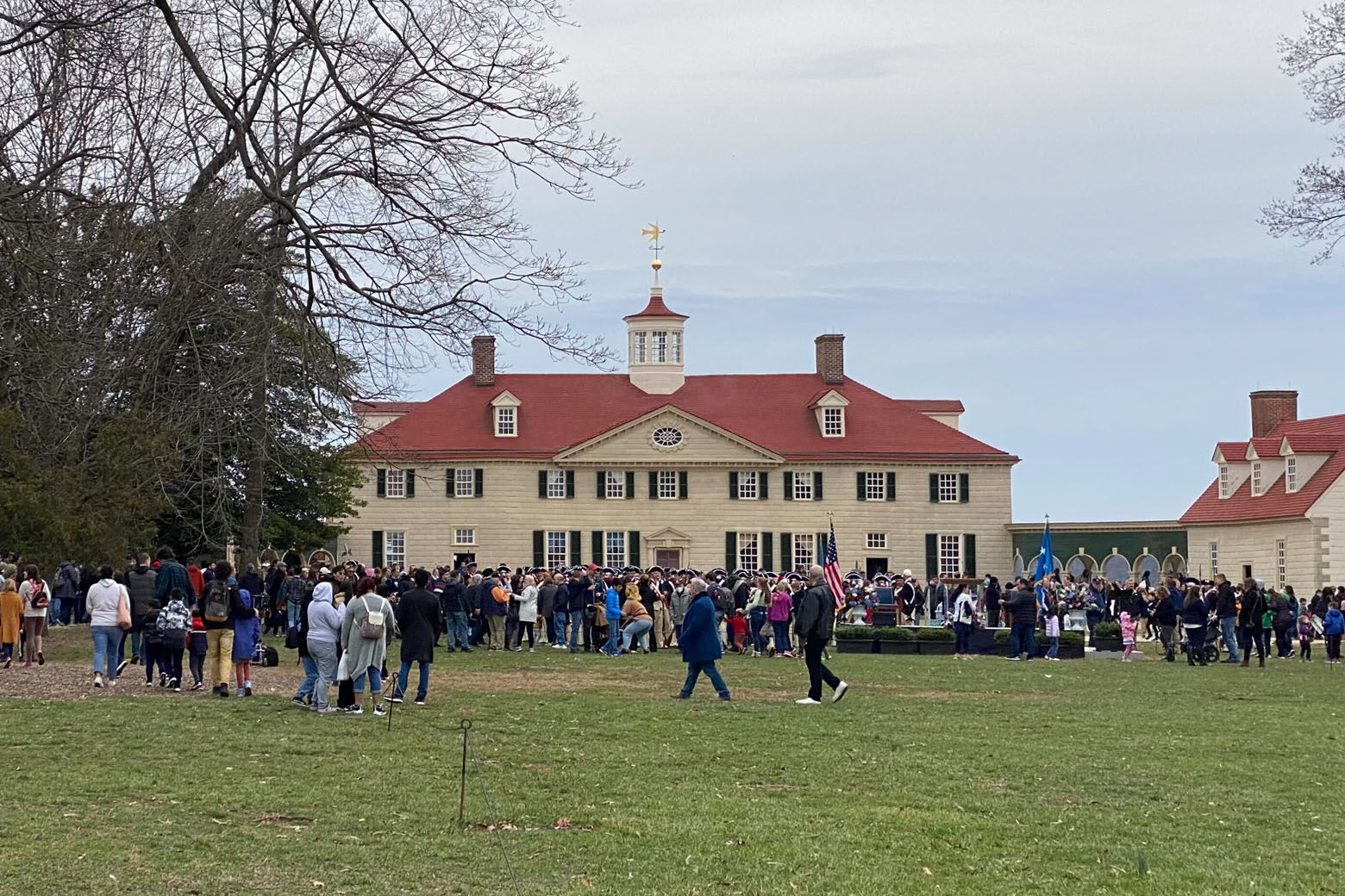  An image of the George Washington estate with a crowd of people walking towards the mansion where an extremely rare cherry cordial bottle was unearthed.