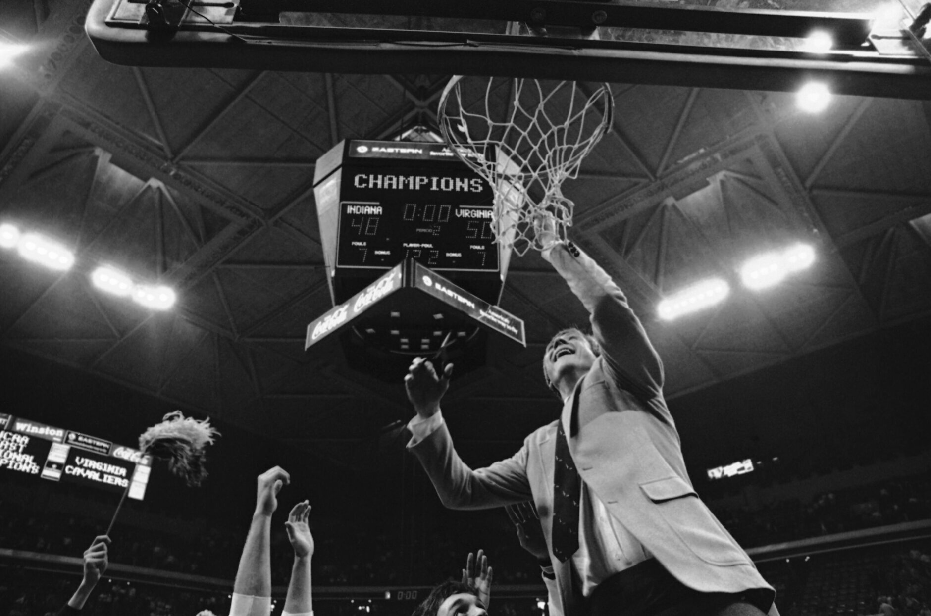 University of Virginia coach Terry Holland cuts the net from the goal with the scoreboard showing his team defeating Indiana University 50-48 in the NCAA East Regional Basketball Finals, Saturday, March 24, 1984, Atlanta, Ga. (AP Photo)
