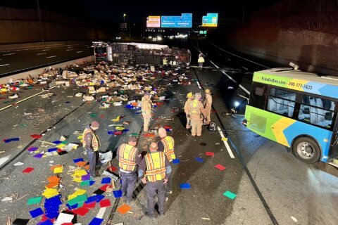 Tractor-trailer transporting colorful paper overturns on I-270