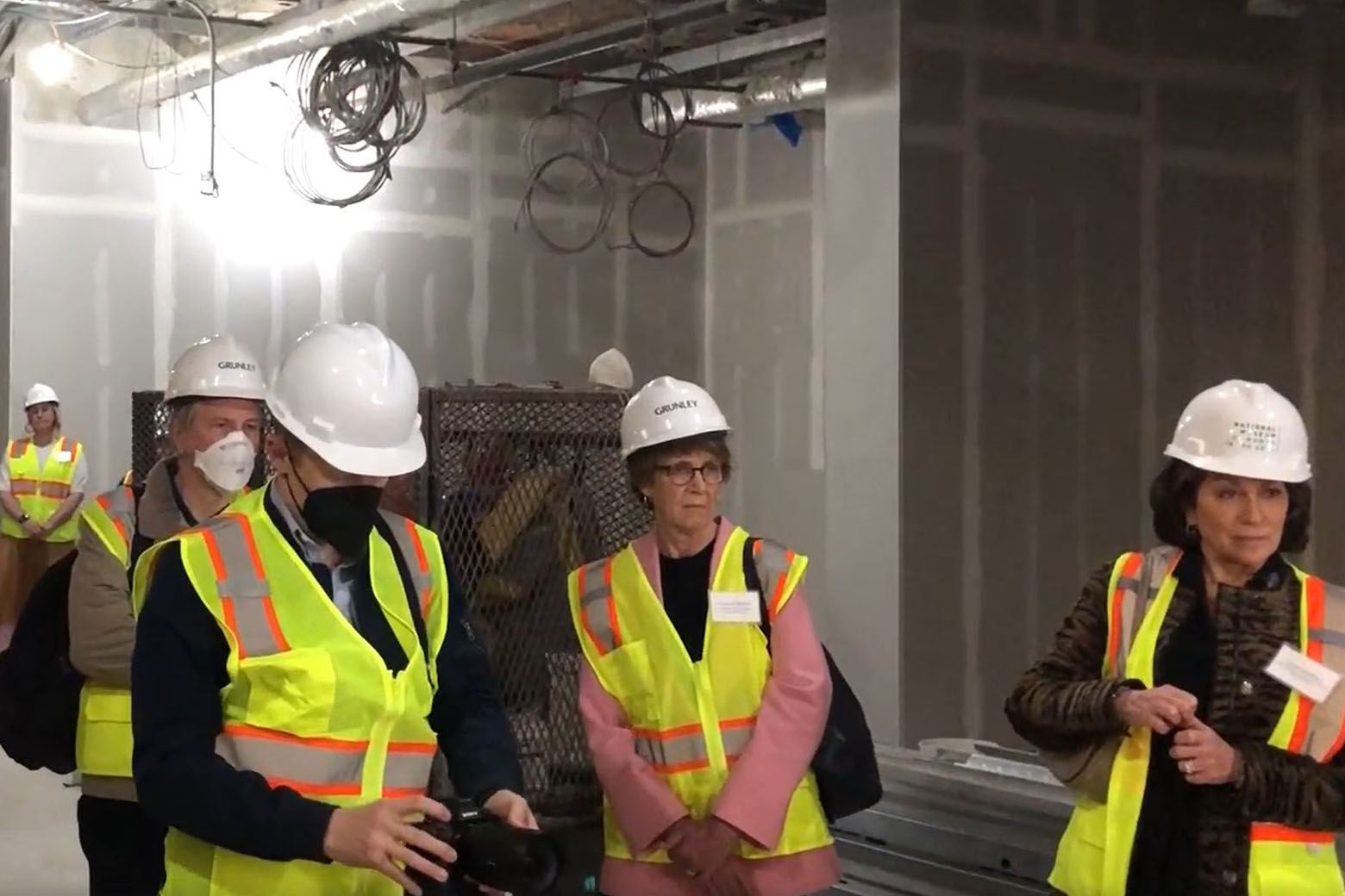 Photo of people wearing hard hats and touring the renovations at the National Museum of Women in the Arts.