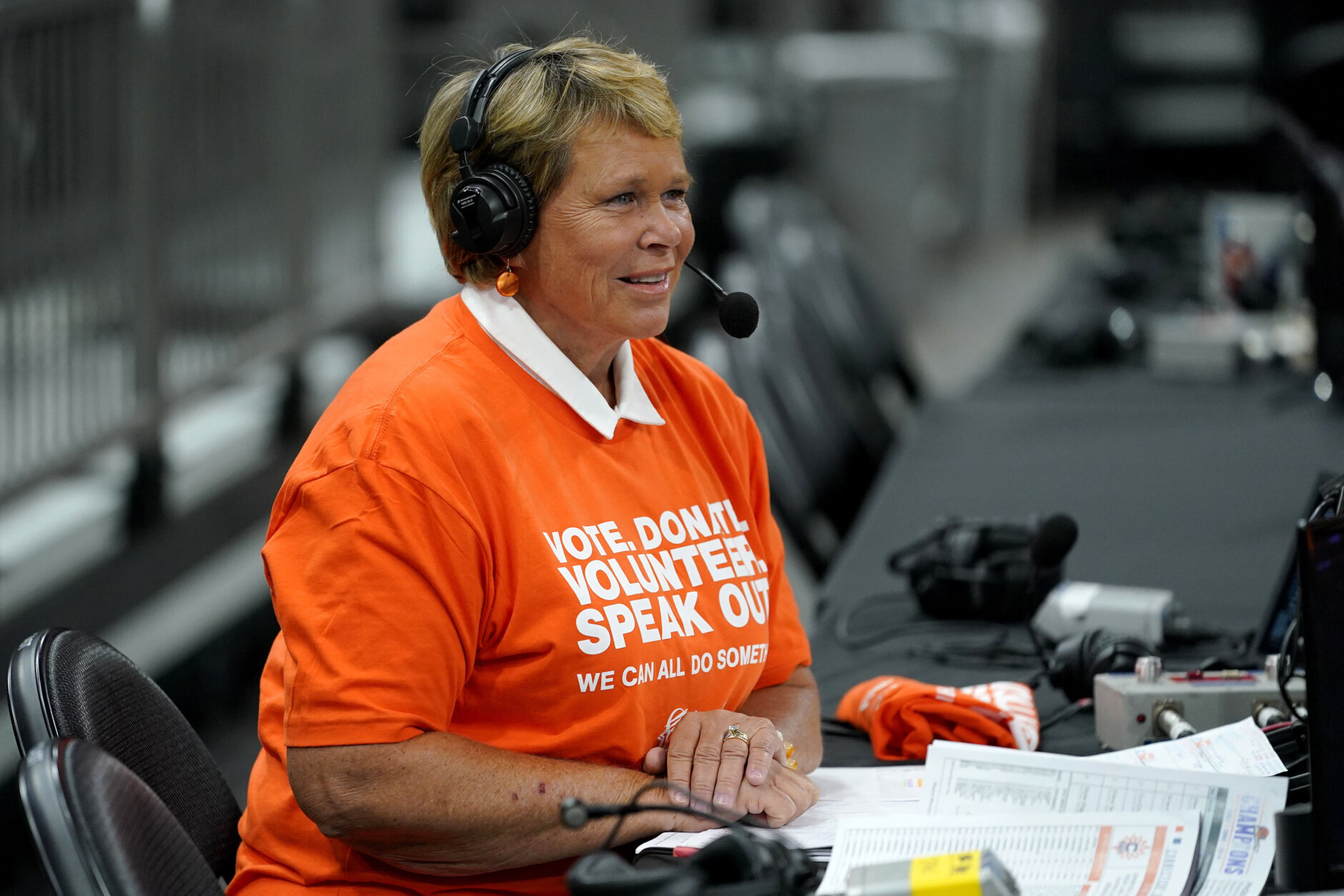 FILE - Ann Meyers Drysdale prepares her court-side broadcast prior to a Phoenix Mercury basketball game, Friday, June 3, 2022 in Phoenix. An all-female ensemble will produce Wednesday's March 8, 2023, game between the Dallas Mavericks and New Orleans Pelicans in New Orleans. It's a way to celebrate International Women’s Day. (AP Photo/Matt York, File)