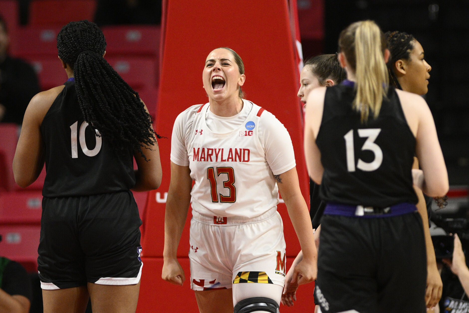 Maryland guard Faith Masonius, center, reacts next to Holy Cross guard Bronagh Power-Cassidy, right, and forward Janelle Allen (10) in the first half of a first-round college basketball game in the NCAA Tournament, Friday, March 17, 2023, in College Park, Md. (AP Photo/Nick Wass)
