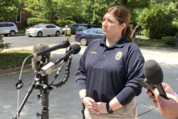 Fairfax City Police spokesman Lisa Gardner prepares to brief reporters outside the office building in Fairfax, Va., where two staffers for U.S. Rep. Gerry Connolly, D-Va., were attacked with a man wielding a baseball bat Monday morning, May 15, 2023. (AP Photo/Matthew Barakat)