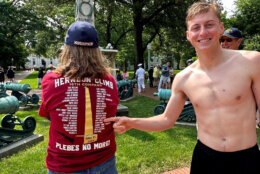 One of the new midshipmen points out his name on a  Herndon Climb 2023 t-shirt (WTOP/Matt Kaufax)