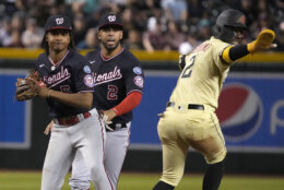 Arizona Diamondbacks' Geraldo Perdomo (2) signals that he is safe on a force-out by Washington Nationals shortstop CJ Abrams (5) in the fourth inning during a baseball game, Friday, May 5, 2023, in Phoenix. (AP Photo/Rick Scuteri)