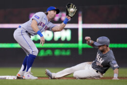 New York Mets second baseman Jeff McNeil catches the throw as Washington Nationals' Jacob Alu steals second base during the second inning of a baseball game at Nationals Park, Friday, May 12, 2023, in Washington. (AP Photo/Alex Brandon)