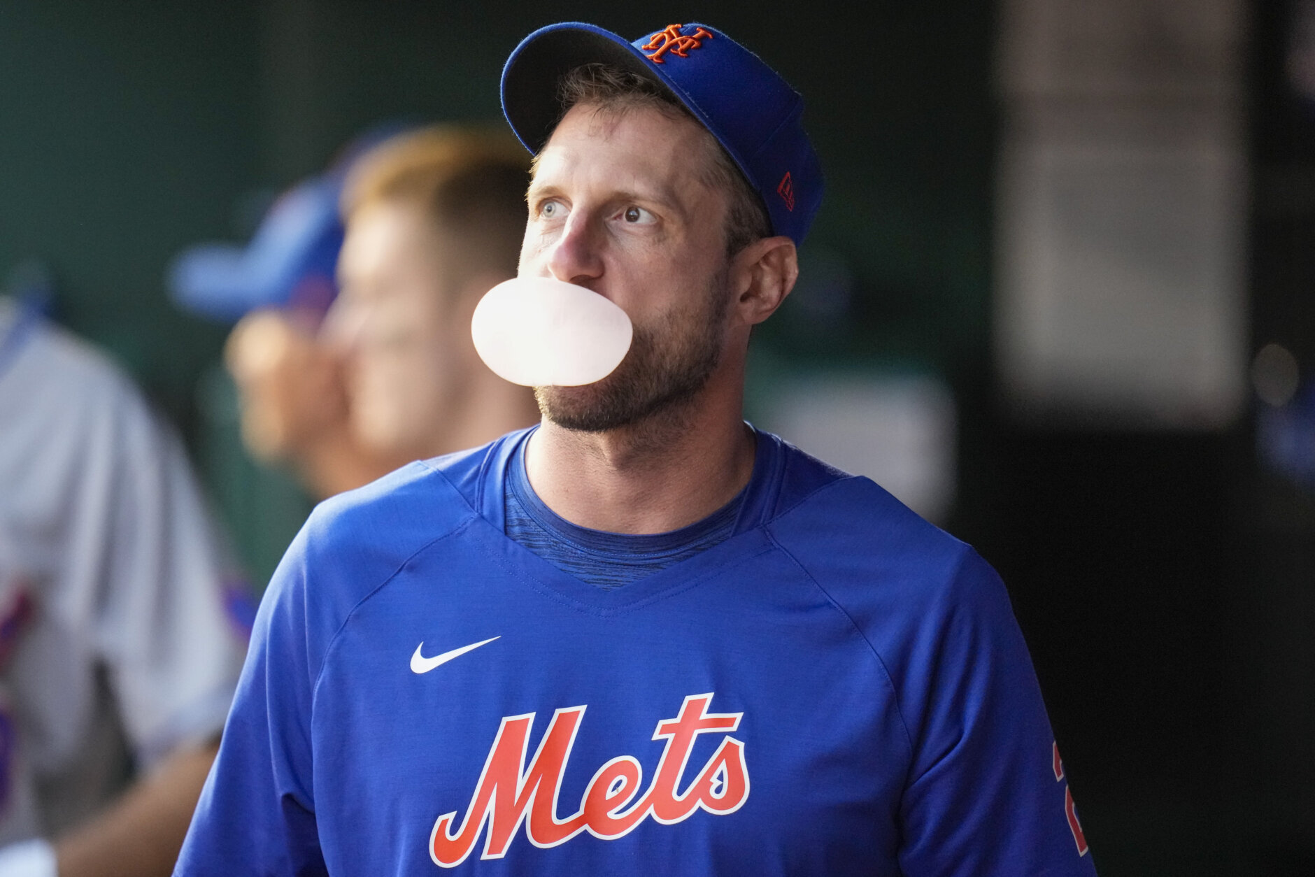 New York Mets starting pitcher Max Scherzer blows a bubble in the dugout during the third inning of the team's baseball game against the Washington Nationals at Nationals Park, Friday, May 12, 2023, in Washington. (AP Photo/Alex Brandon)