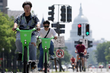 WASHINGTON, DC - JULY 28: With the U.S. Capitol is seen in the background, people ride bicycles on Pennsylvania Avenue on July 28, 2023 in Washington, DC. Extreme heat is forecasted in the DC area thru Saturday with a heat index reaching up to 110 degrees. (Photo by Alex Wong/Getty Images)