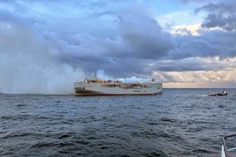 A freighter carrying nearly 3,000 cars catches fire in the North Sea and a crew member is killed